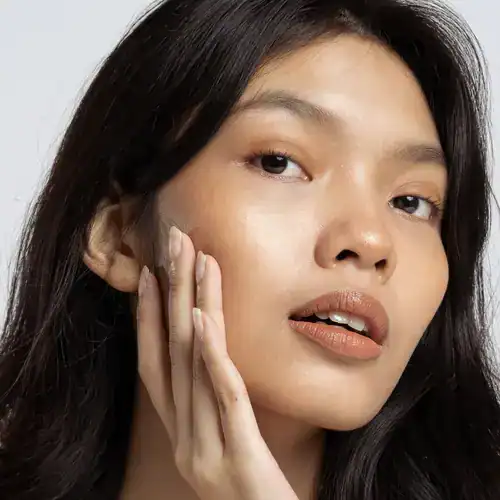Woman applying toner to her face