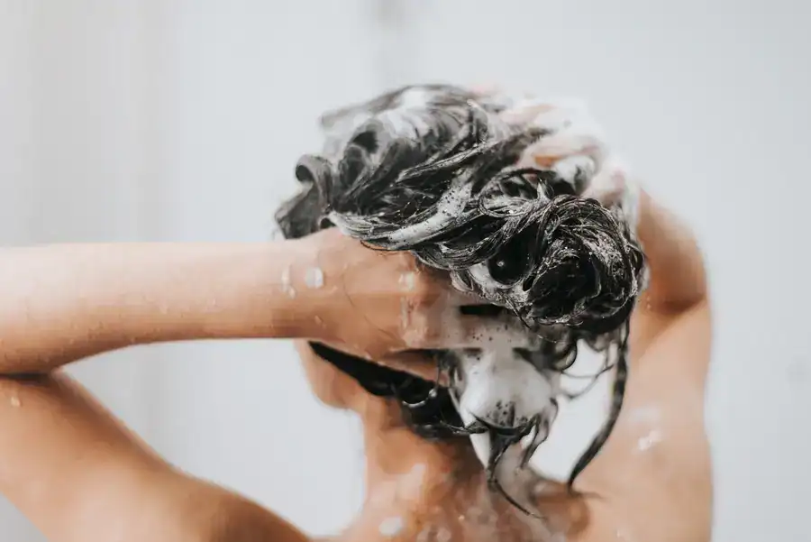 Woman applying shampoo during shower